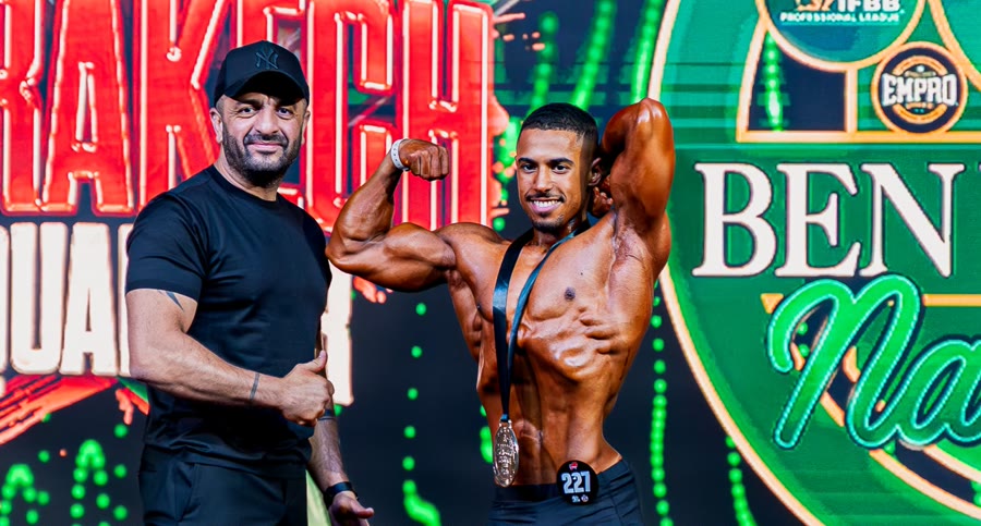 Youness biceps pose with medal